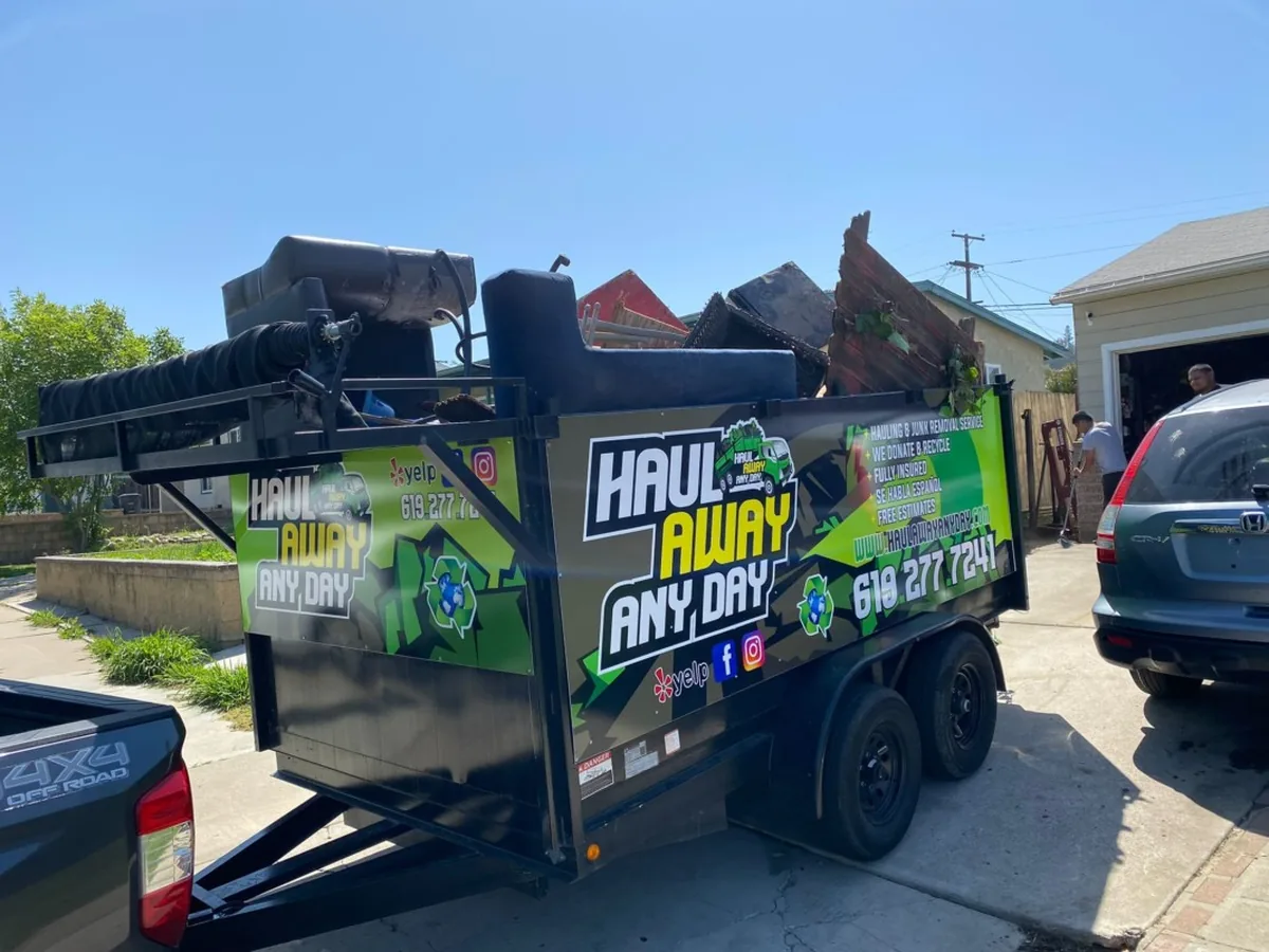 Haul Away Any Day wrapped trailer on a job