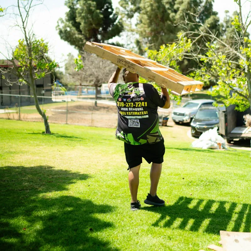 Crew member carrying wooden pallets to the trailer