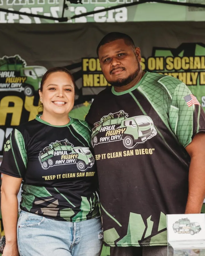 The owners of Haul Away Any Day at a community event booth